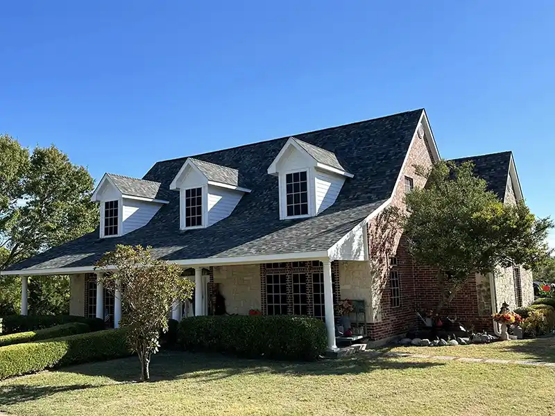 Mid-class home with new dark gray shingles installed on its roof by Kime Construction